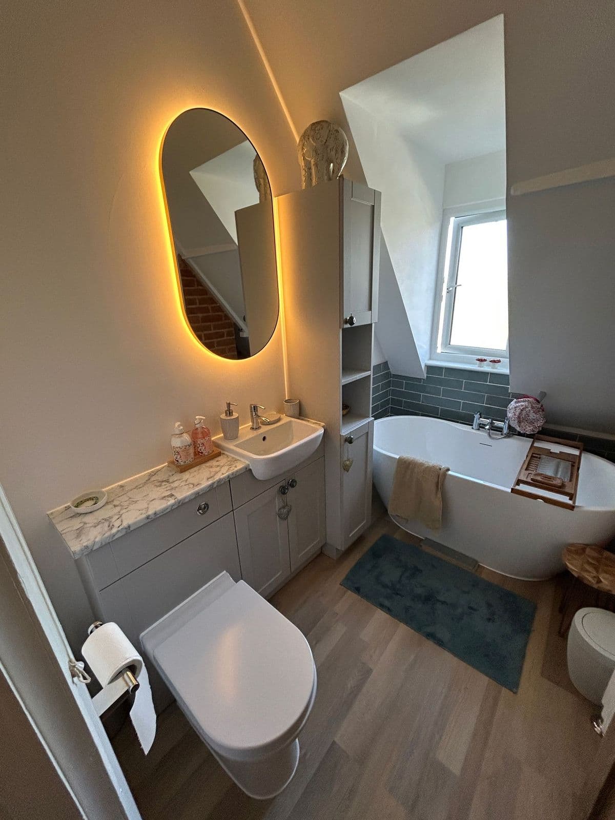 Family bathroom with a freestanding bath and backlit mirror