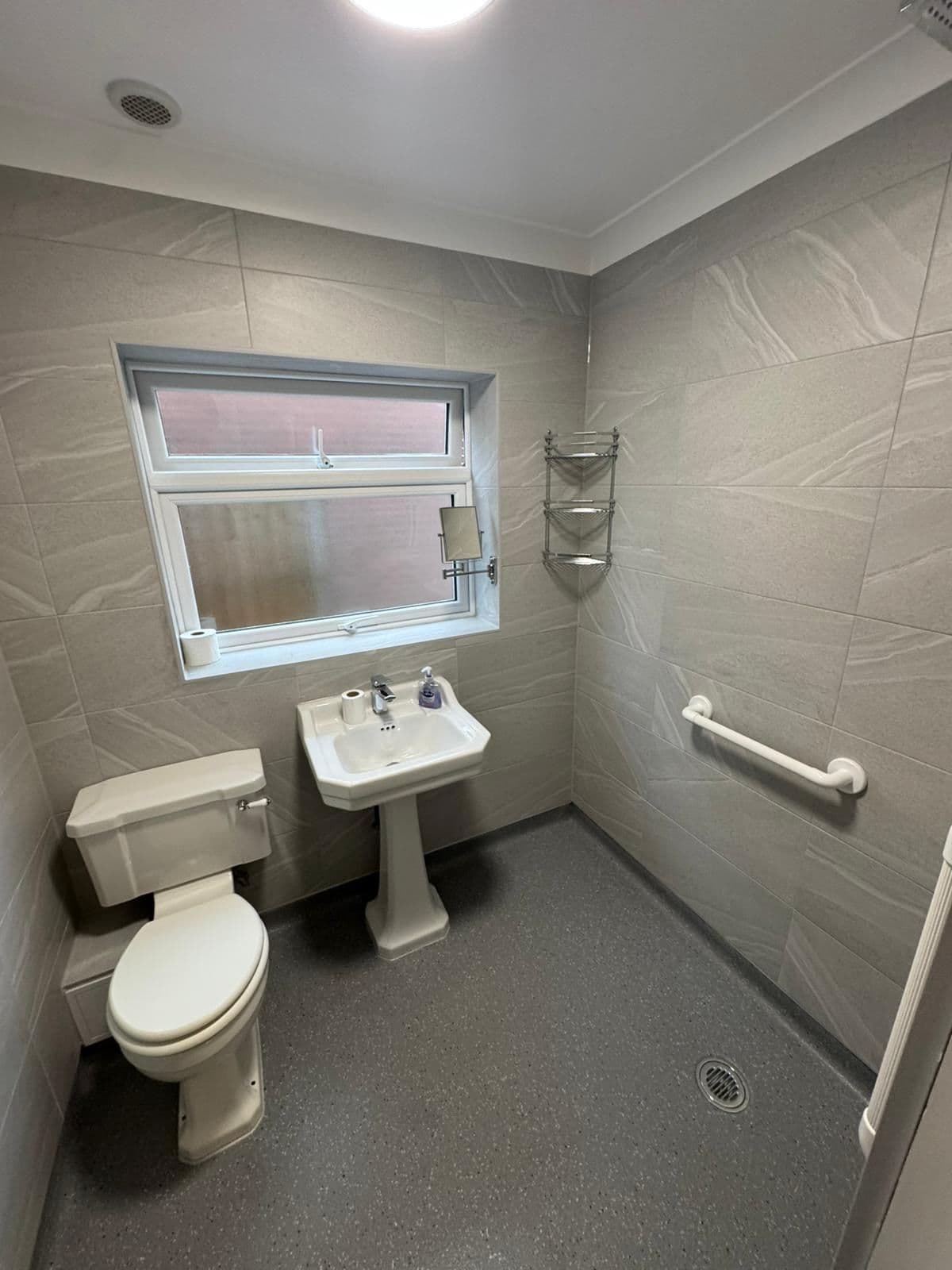 Accessible wet room with anti-slip flooring and support rails