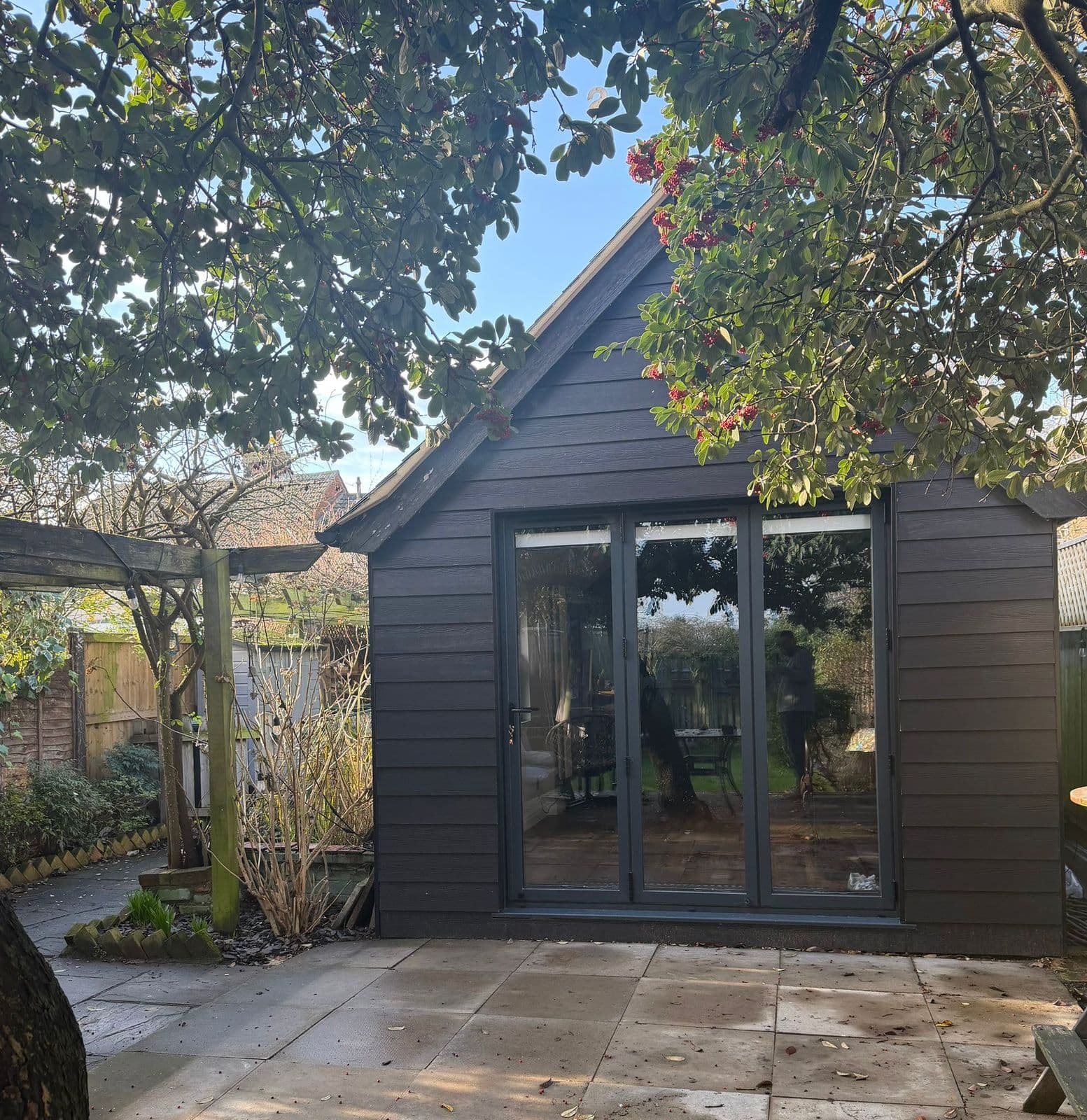 Anthracite garden studio with bifold doors and a paved terrace